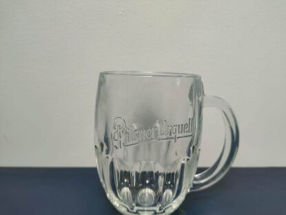 Kufel Pilsner Urquell z uchem po prawej i wyraźnie widocznym logo czeskiego browaru