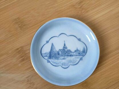 Talerz manifaktury B&G Bing & Grondhal z niebieską grafiką przedstawiającą zabudowania z oddali