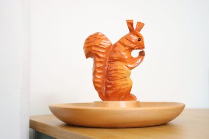 Piękny talerz na orzechy z wiewiórką jako dziadkiem do orzechów widoczny z profilu prawego wiewiórki