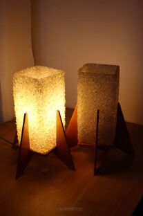 2 lampki nocne Rakiety  Pokrok Žilina wieczorem, z czego jedna zapalona dająca ciepłe światło