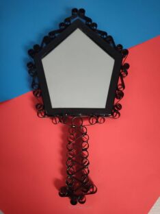 Lusterko metaloplastyka w kształcie pięciokąta na czerwono-niebieskim tle