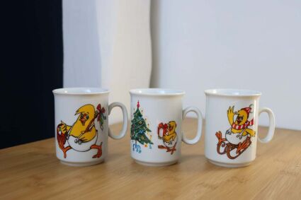 3 kubki świąteczne równo w rządku obok siebie z wielkanocnymi motywami i uszkami po prawej