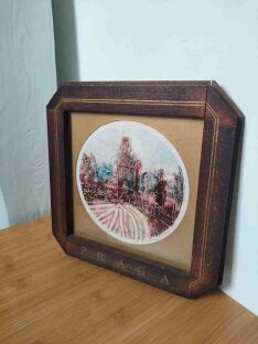 Litografia z Pragą Josefa Mokráčka w brązowej ramce oparta o białą powierzchnię