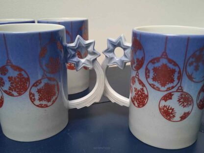 2 kubki świąteczne  Porcelán Dubí stojące pięknymi uchwytami z gwiazdką do siebie i 2 z tyłu
