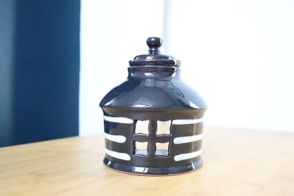 Kominek czarny wpadający w granat w kształcie domku z okienkiem i białymi pasami