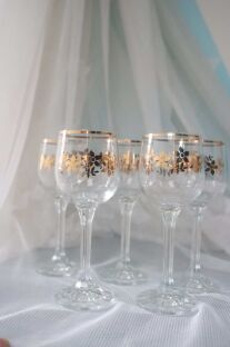 5 kieliszków Bohemia sklo ze złoceniami rozstawionych po 2 i 3 na tle firanki