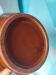 Podstawa ceramicznego brązowego dzbana na niebieskim tle