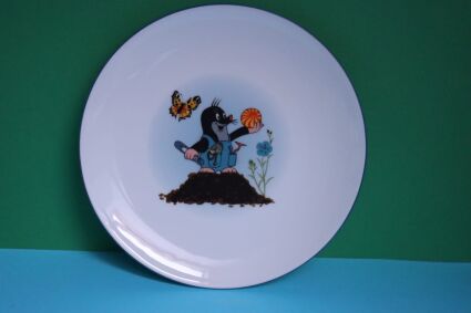 Talerz płaski Porcelán Thun z krecikiem w niebieskich monterkach w kopcu z piłką w ręce