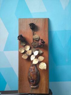 Obraz 3D na desce z wyraźnymi różami oparty o niebieską tapetę